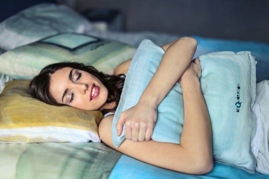 A woman sleeping peacefully in bed hugging a Hypoallergenic Pillows, evoking comfort and relaxation.