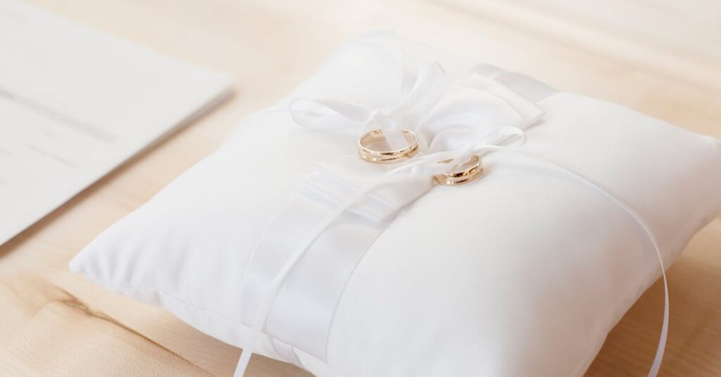 Gold wedding rings elegantly displayed on a white satin pillow, symbolizing love and commitment.